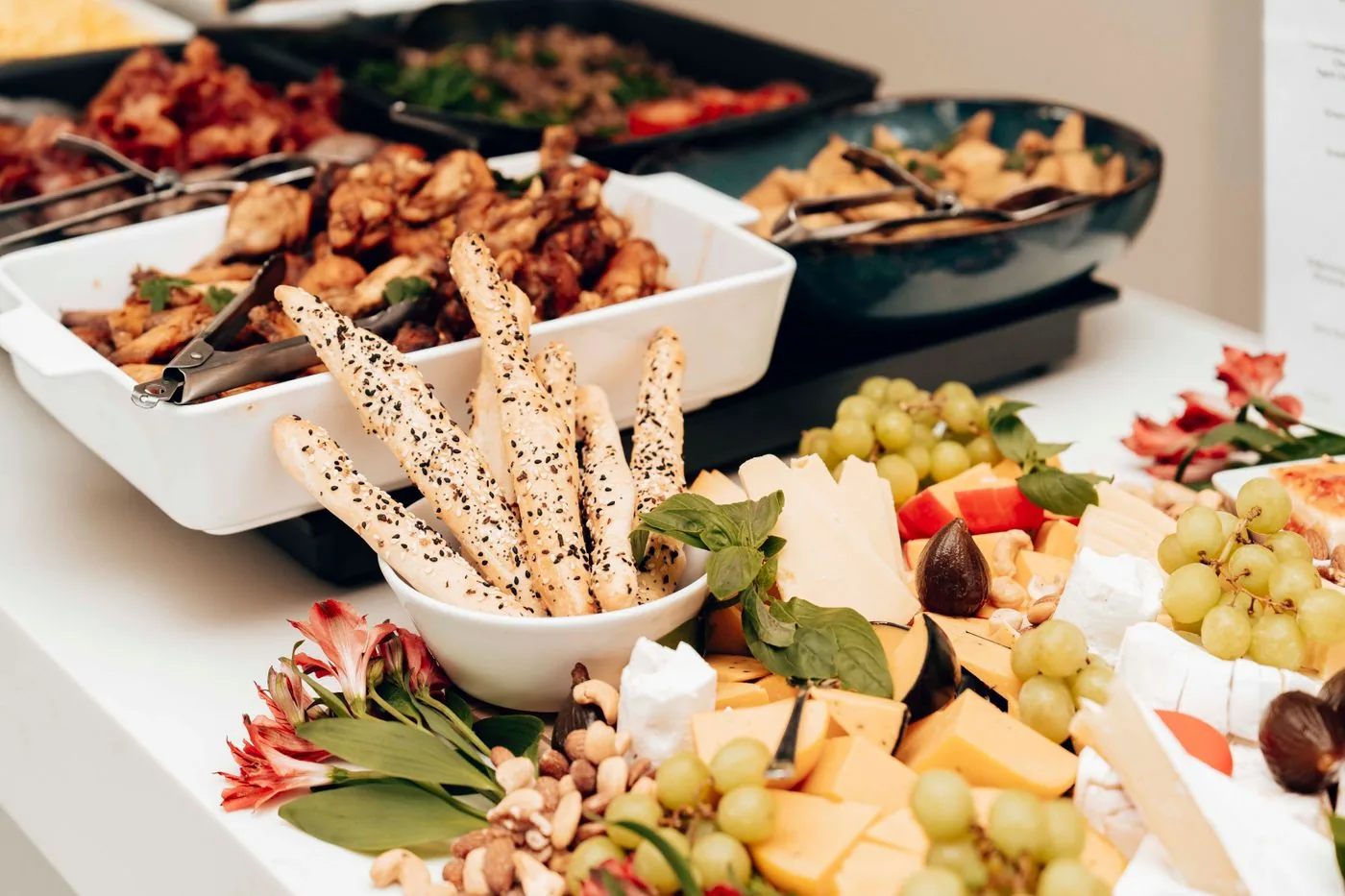 A catered buffet with warm dishes, bread and a grazing board