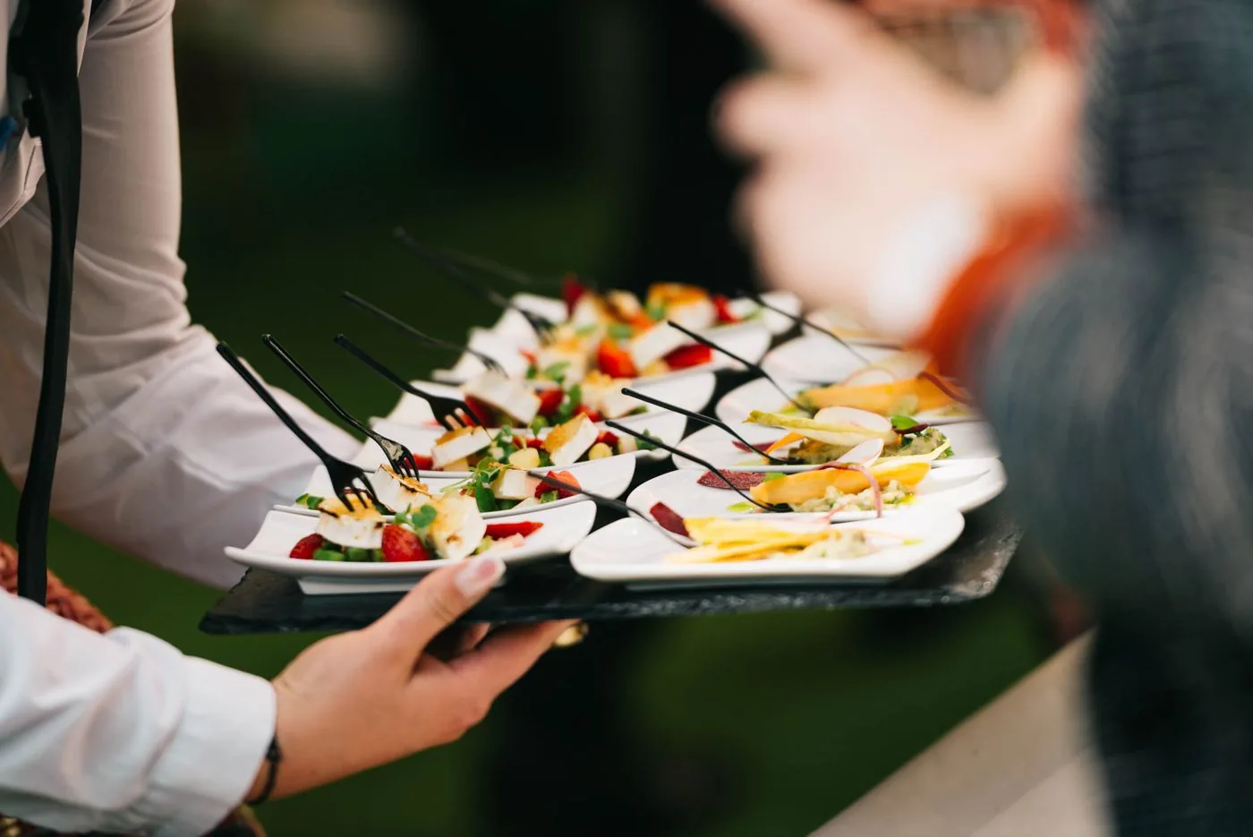 A server carrying a tray of canapé bites