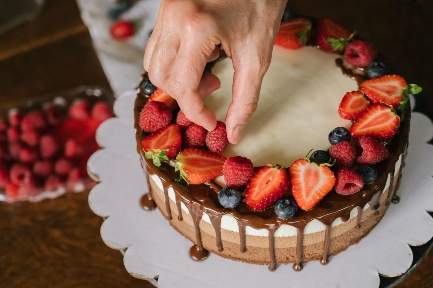 A chef finishing a chocolate dessert with fresh berries