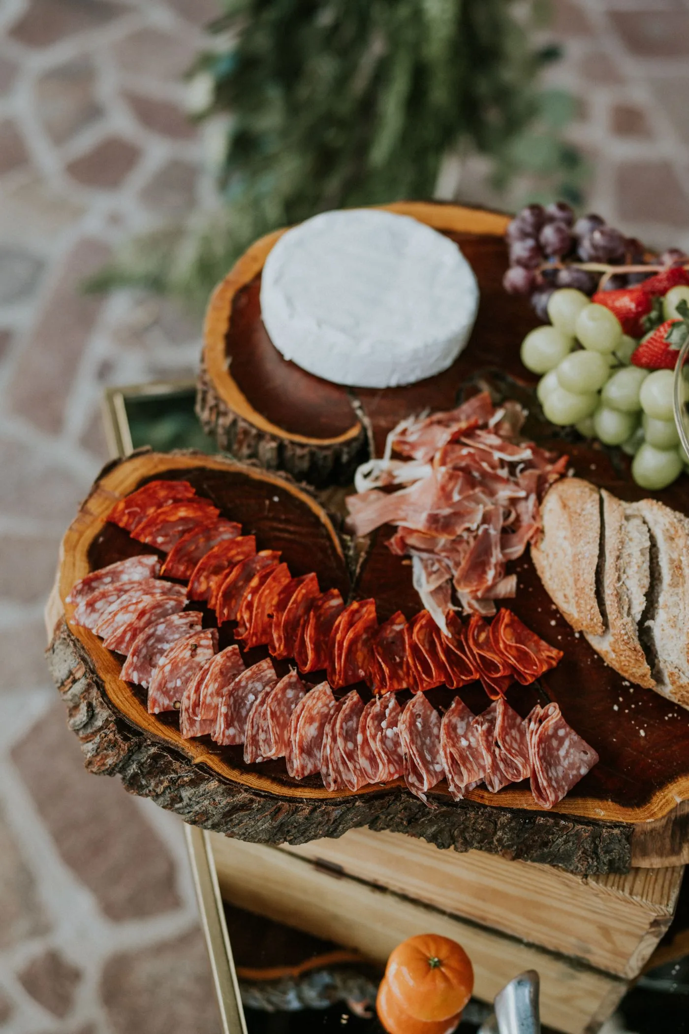 A styled board of artisan cheeses, cured meats and fruit